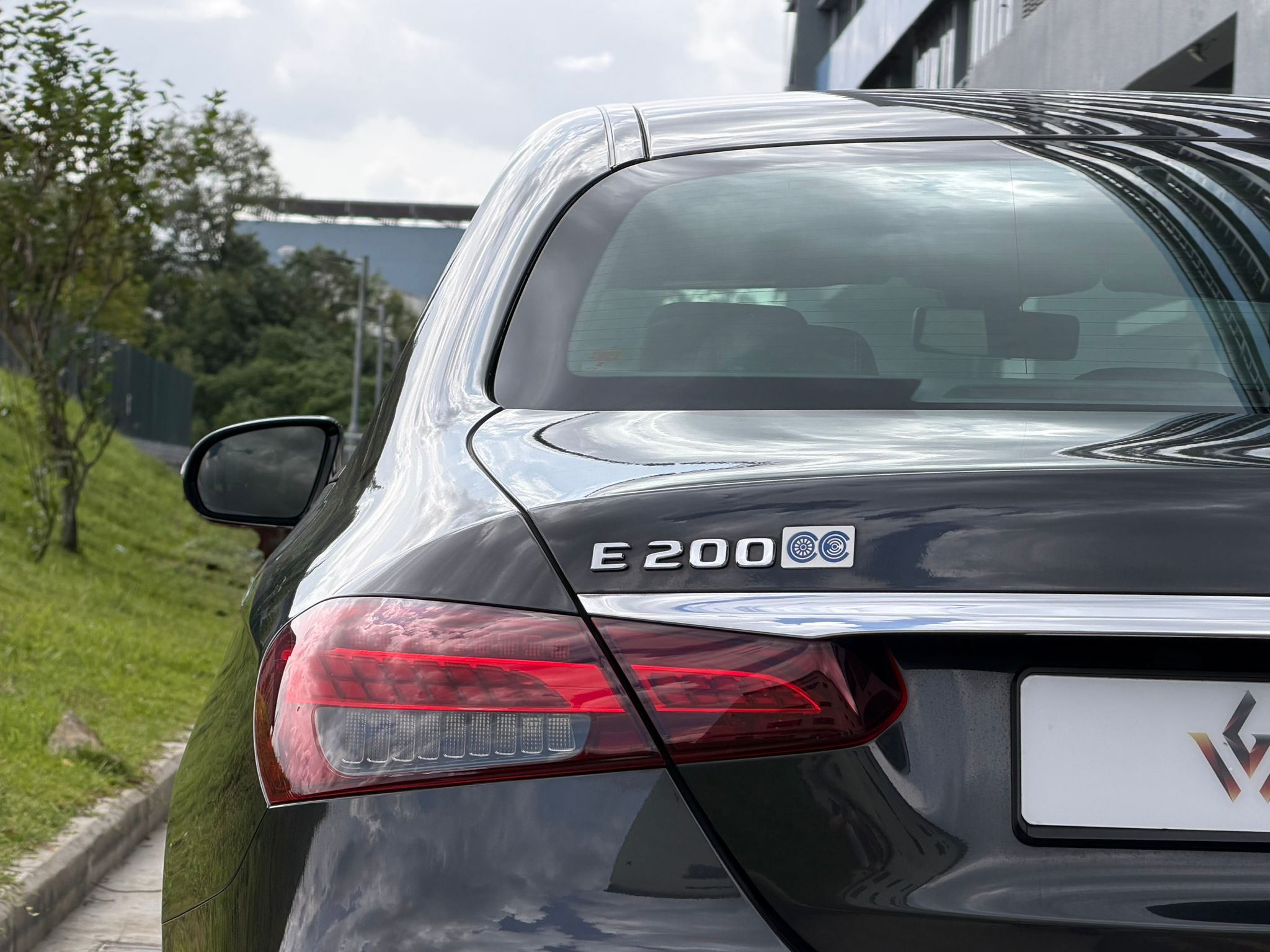 Close-up of Mercedes-Benz E200 badge and chrome detailing on trunk.
