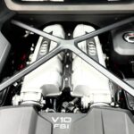 Close-up of the mid-mounted 5.2L FSI V10 engine under the carbon fiber cross-brace in an Audi R8.