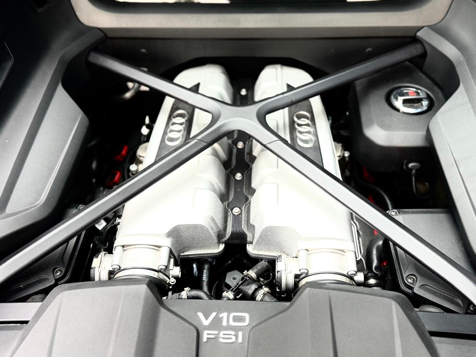 Close-up of the mid-mounted 5.2L FSI V10 engine under the carbon fiber cross-brace in an Audi R8.