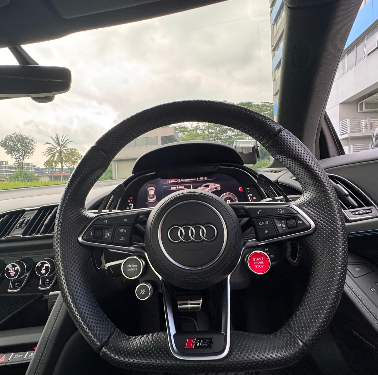 Audi R8 multifunctional leather steering wheel with red start engine button and Virtual Cockpit display.