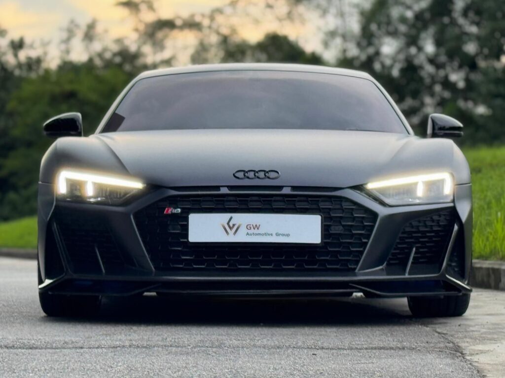Front profile of a matte grey Audi R8 V10 Performance with signature LED daytime running lights.