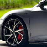 Detailed view of Audi Sport alloy wheels with red brake calipers and V10 badging on the side fender.