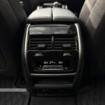 Digital rear climate control screen in a BMW X7 showing 5-zone temperature settings for passengers.