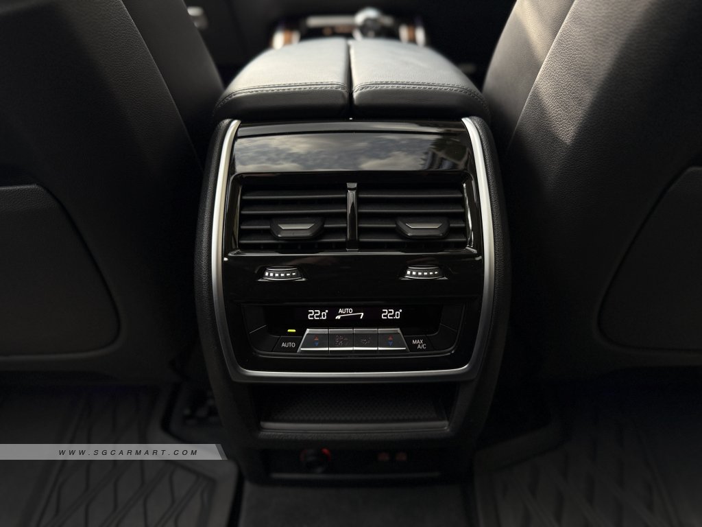 Digital rear climate control screen in a BMW X7 showing 5-zone temperature settings for passengers.