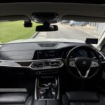 Center console of a BMW X7 featuring the wood trim and CraftedClarity glass applications.