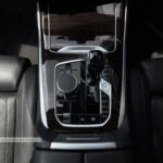 Center console of a BMW X7 featuring the wood trim and CraftedClarity glass applications.