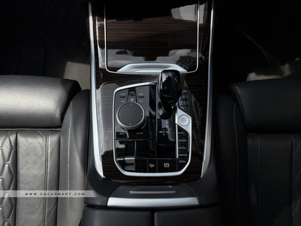 Center console of a BMW X7 featuring the wood trim and CraftedClarity glass applications.