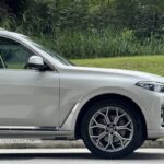 Side view of a white BMW X7 xDrive40i showing alloy wheels and chrome exterior trim.