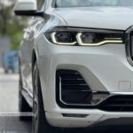Close-up of BMW X7 LED headlights and signature kidney grille on a white Pure Excellence model.