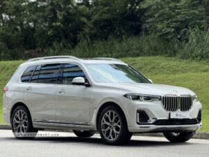 High-angle front view of a white BMW X7 xDrive40i Pure Excellence with the Iconic Glow kidney grille.