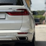 Rear view of BMW X7 showing the xDrive40i badge, split tailgate, and chrome exhaust surrounds.