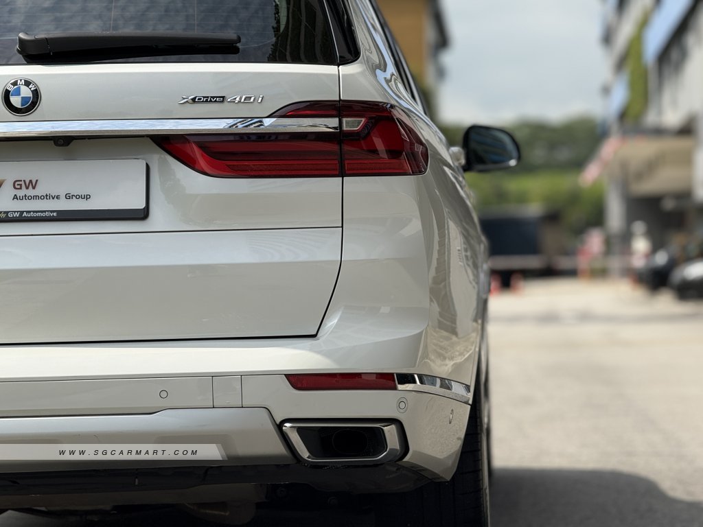 Rear view of BMW X7 showing the xDrive40i badge, split tailgate, and chrome exhaust surrounds.