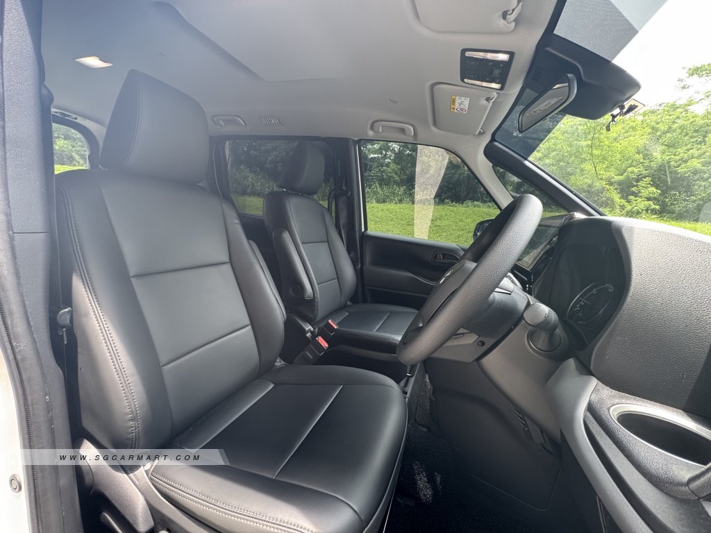 Premium black leather upholstery in the front cabin of a 7-seater Toyota Noah Hybrid.