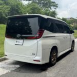 Rear view of the Toyota Noah Hybrid highlighting the vertical LED taillights and hybrid badging.