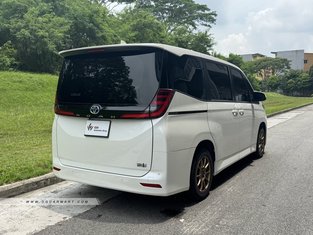 Rear view of the Toyota Noah Hybrid highlighting the vertical LED taillights and hybrid badging.